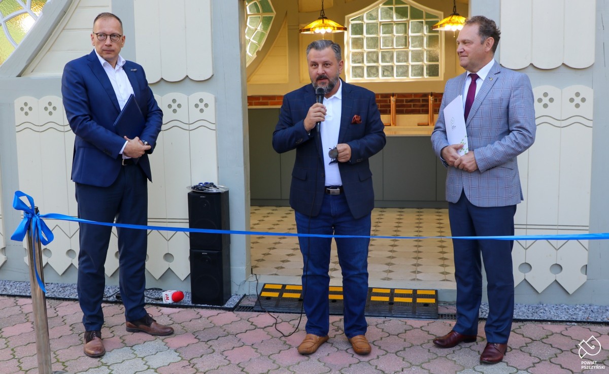 przemawia paweł sadza, obok wicestarosta i prezes uzdrowiska przed budynkiem pijalni.