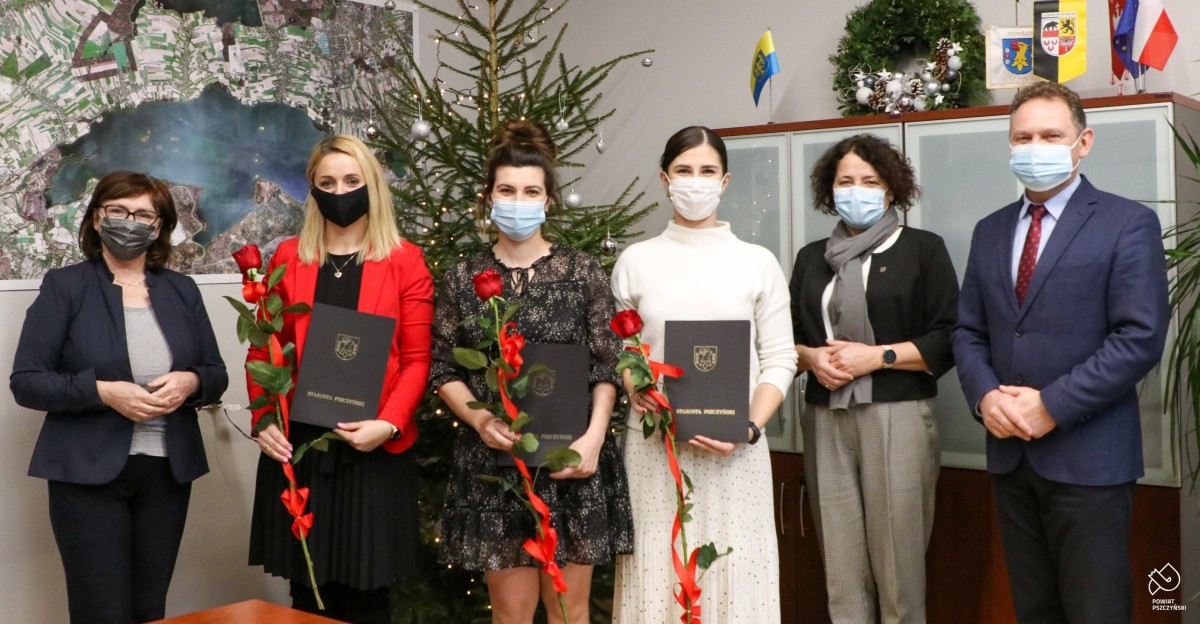 Trzy nauczycielki mianowane stoją przed choinką w gabinecie starosty razem ze starostą wocestarostą i naczelniczką wydziału.