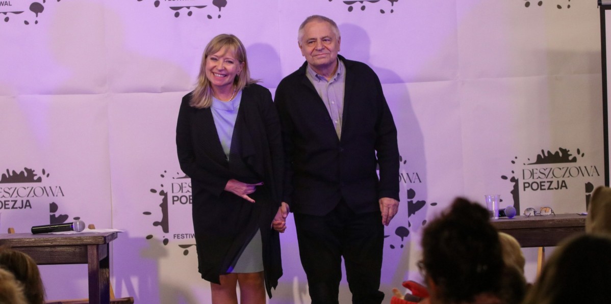 Dorota Segda i Jacek Romanowski trzymają się za ręce i uśmiechają się stojąc na scenie