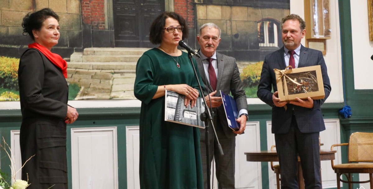 starosta, wicestarości i dyrektor stoją na scenie.